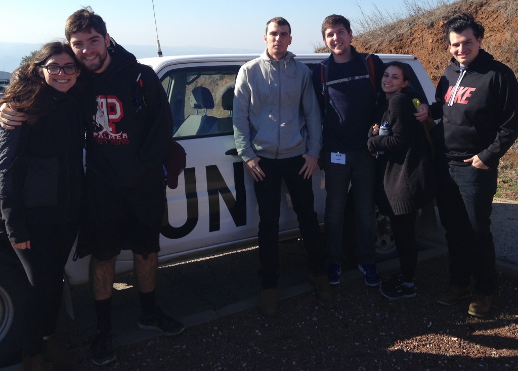 Staff members pose for a picture next to a United Nations vehicle at Mount Bental near the border with Syria.